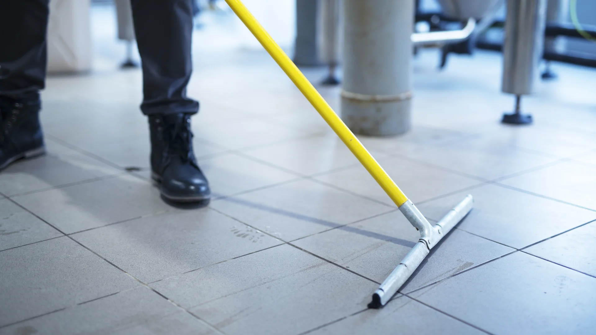 Worker mopping industrial tile floor