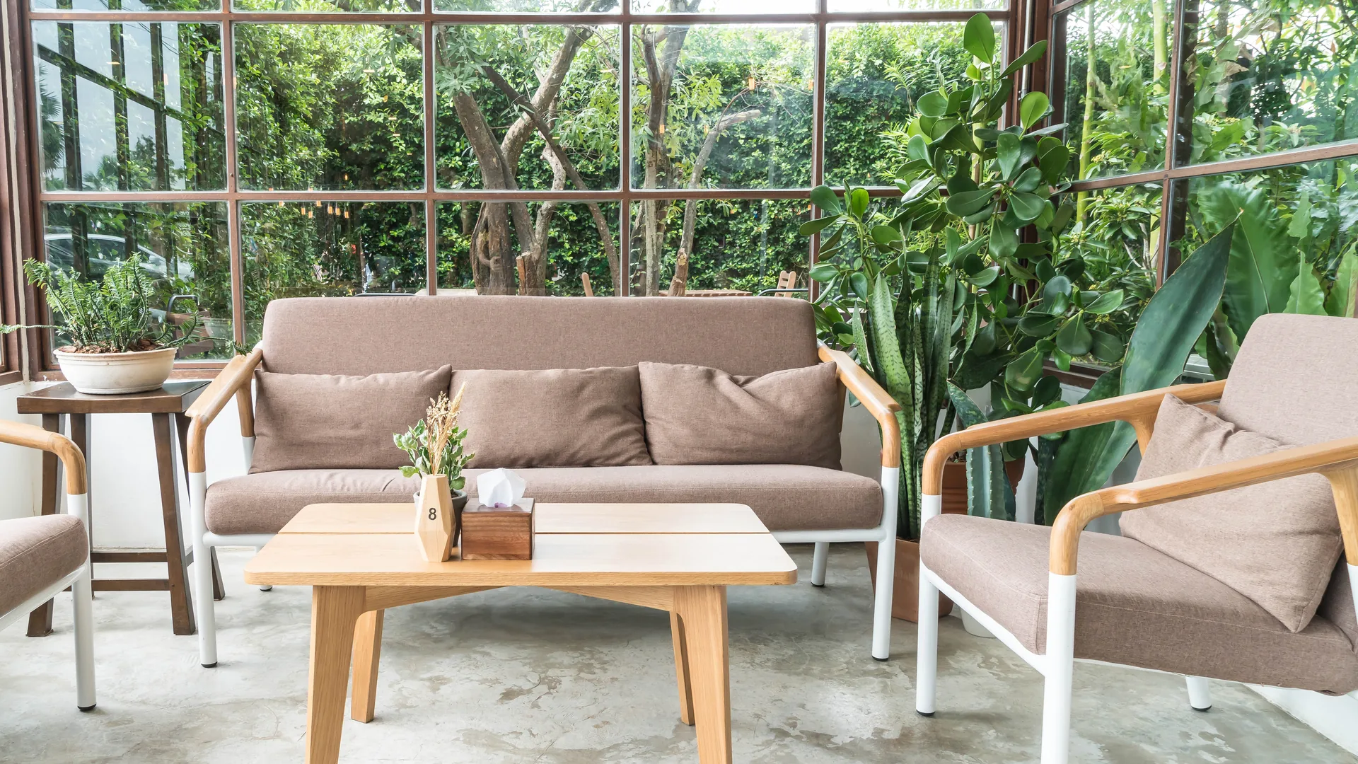 Wood-framed sofa and chairs in tropical living room
